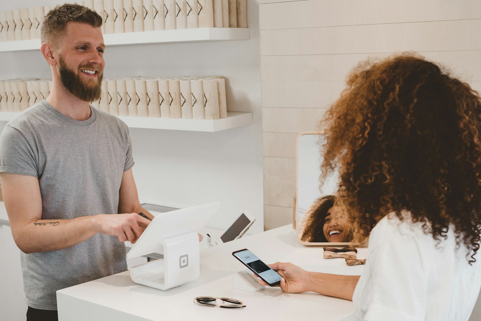 Commerçant souriant dans sa boutique en accueillant un client